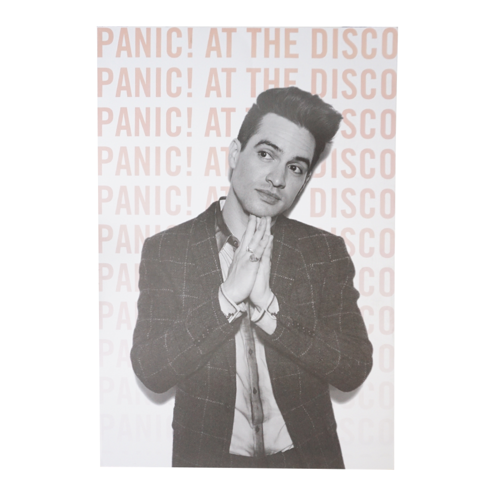 Black and white photograph of a young man in a checkered suit jacket with his hands clasped in front of him.