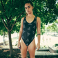Black one-piece swimsuit with white geometric pattern.